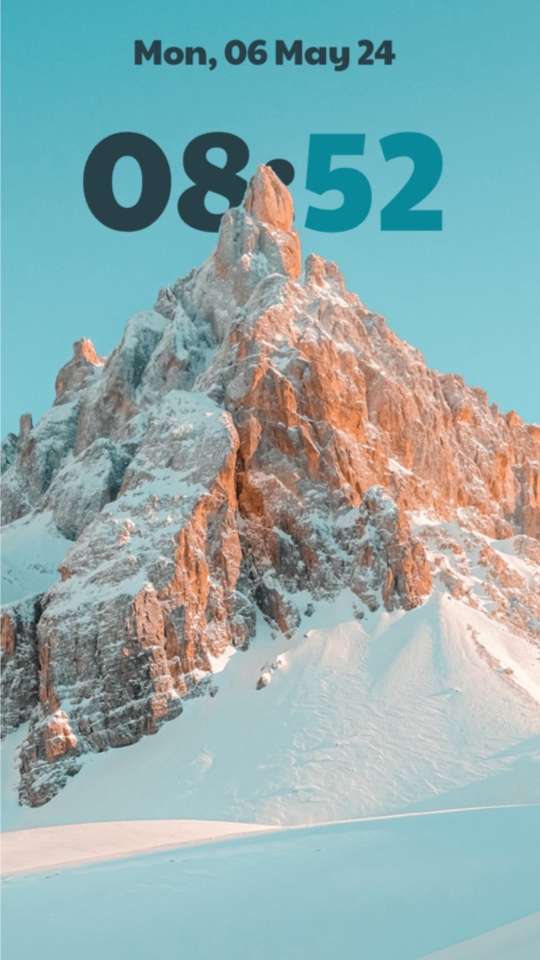 A snowy, sunlit mountain peak against a teal sky, with a dark teal and bright teal 08:52 clock whose digits slip behind the summit.